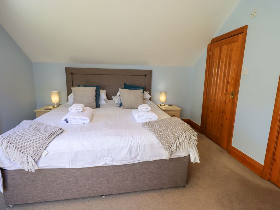 A bedroom with a double bed and bedside lamps at Waterhead Cottage, Ecclerigg, near Troutbeck Bridge