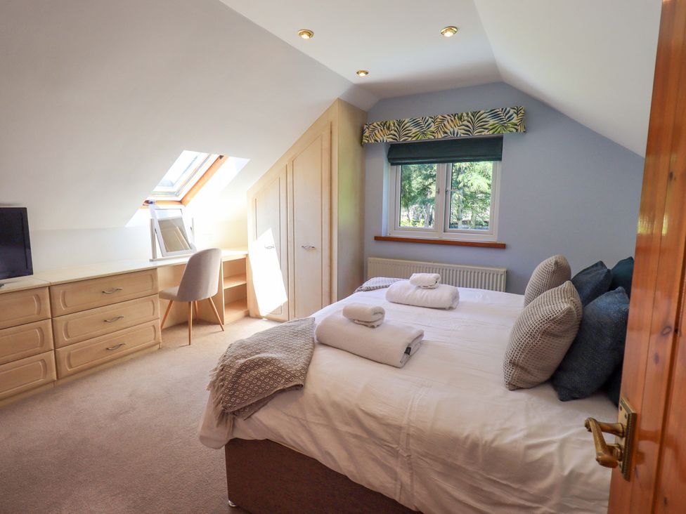 A bedroom with a bed and dresser at Waterhead Cottage, Ecclerigg, near Troutbeck Bridge