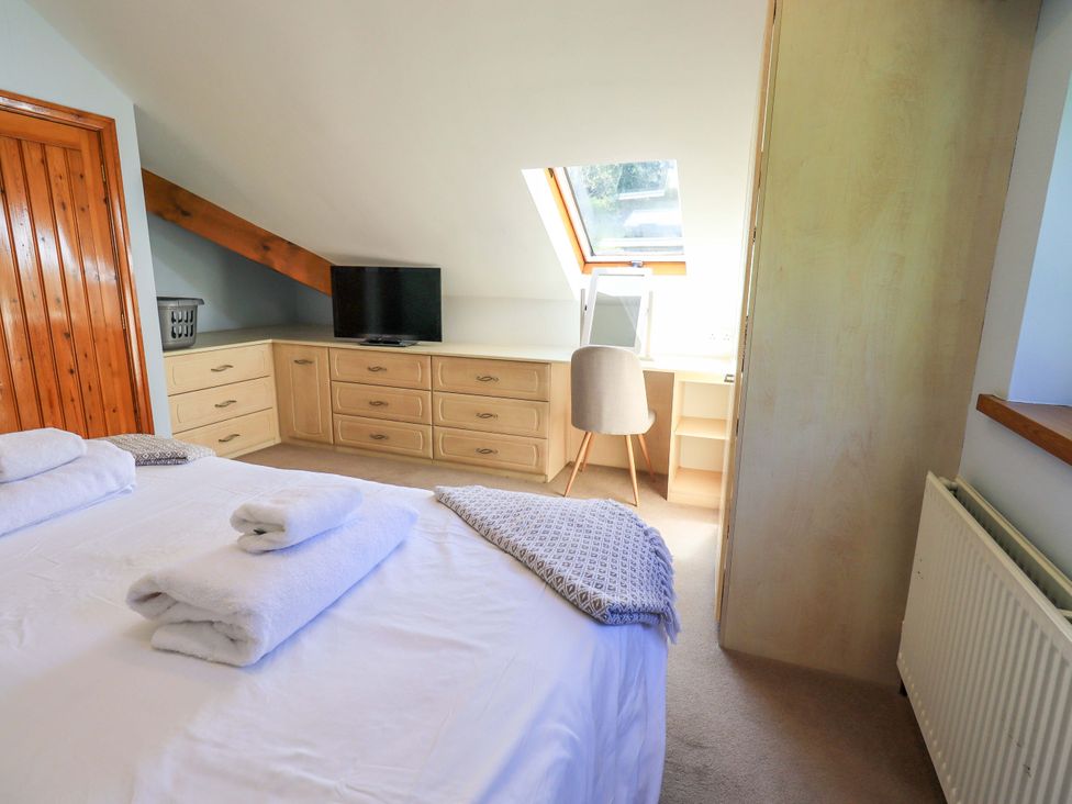 A bedroom with a bed and television at Waterhead Cottage in Ecclerigg, near Troutbeck Bridge