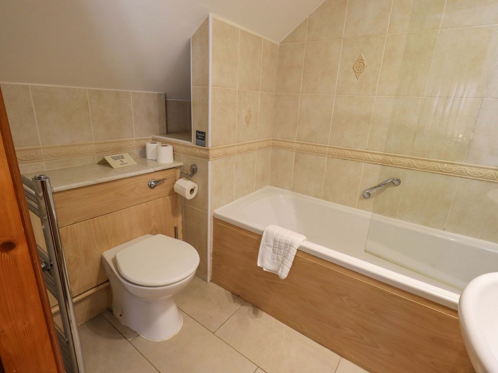 A bathroom with toilet, bathtub, and sink at Waterhead Cottage, Ecclerigg, near Troutbeck Bridge