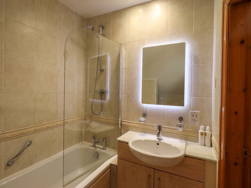 A bathroom with a bathtub and shower at Waterhead Cottage in Ecclerigg, near Troutbeck Bridge