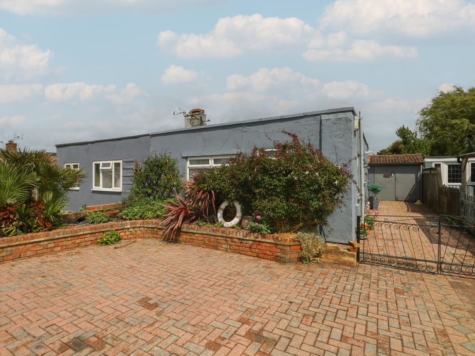 A house with garden features and a brick pathway at Bay Cosy, Pevensey Bay