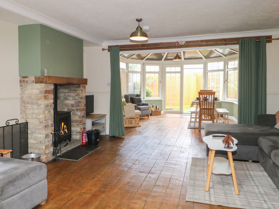 A living room with a fireplace and seating area at Bay Cosy in Pevensey Bay