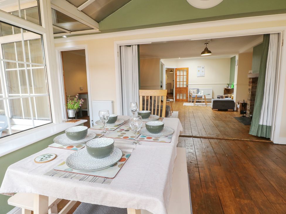 A dining room with a table set for dinner at Bay Cosy in Pevensey Bay