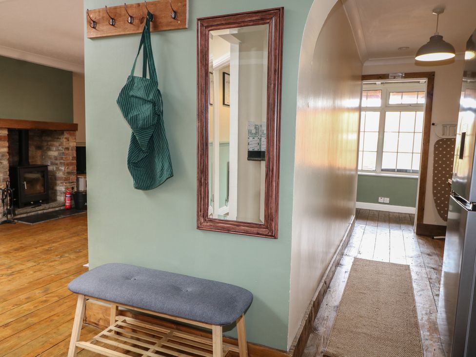 A hallway with a bench and coat hooks at Bay Cosy in Pevensey Bay