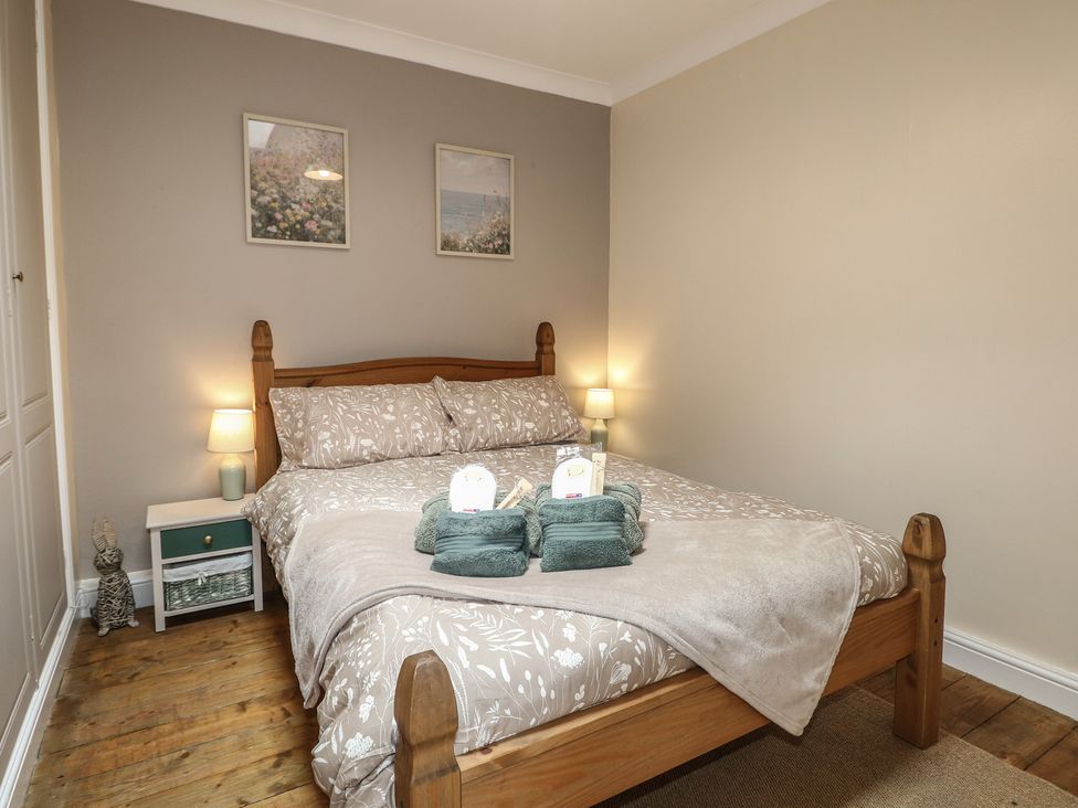 A bedroom with a bed and bedside table at Bay Cosy in Pevensey Bay