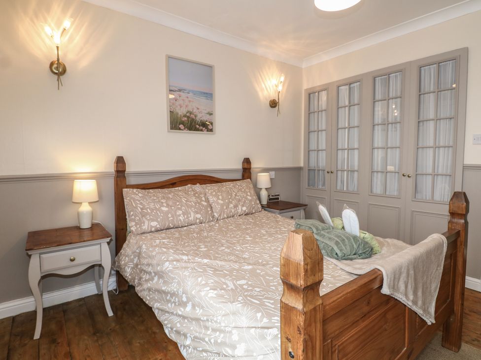 A bedroom with a bed and nightstand at Bay Cosy Pevensey Bay