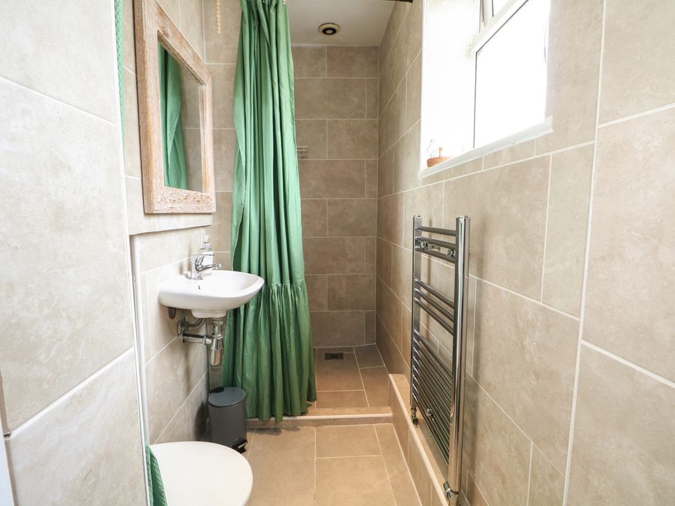 A bathroom with a sink, toilet, and shower at Bay Cosy in Pevensey Bay