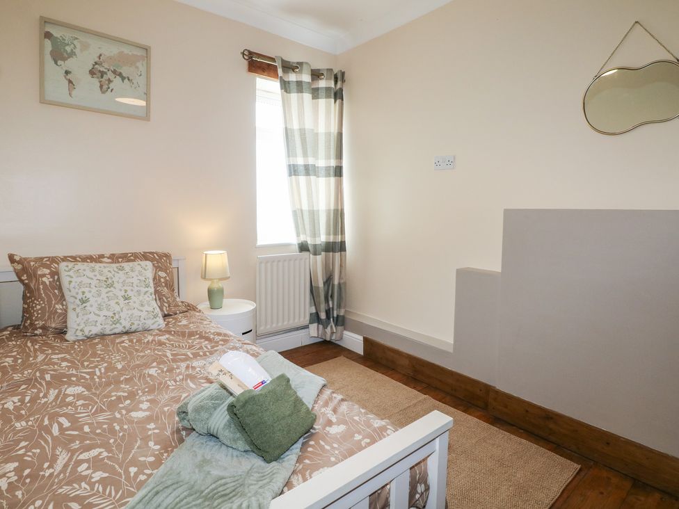 A bedroom with a bed and a lamp at Bay Cosy Pevensey Bay