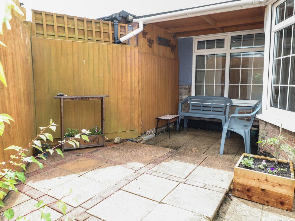 A garden with a bench and table at Bay Cosy in Pevensey Bay