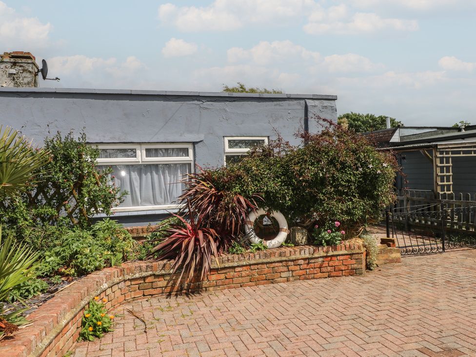 An outdoor area with plants and a house at Bay Cosy in Pevensey Bay