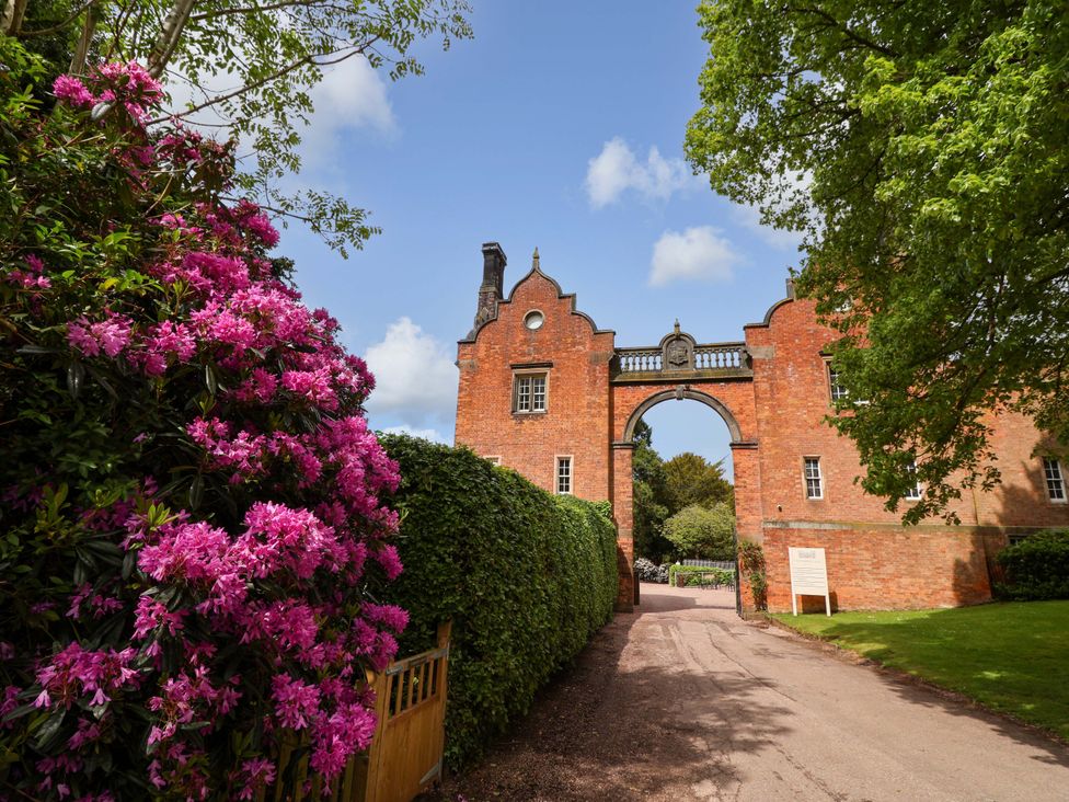 A gate with flowers and hedges at South Tower Cottage Capesthorne near Macclesfield