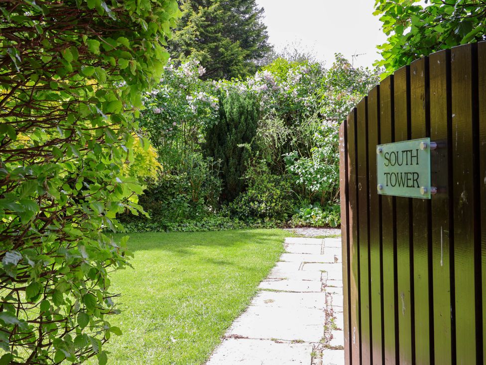 A garden with a pathway and gate at South Tower Cottage Capesthorne near Macclesfield