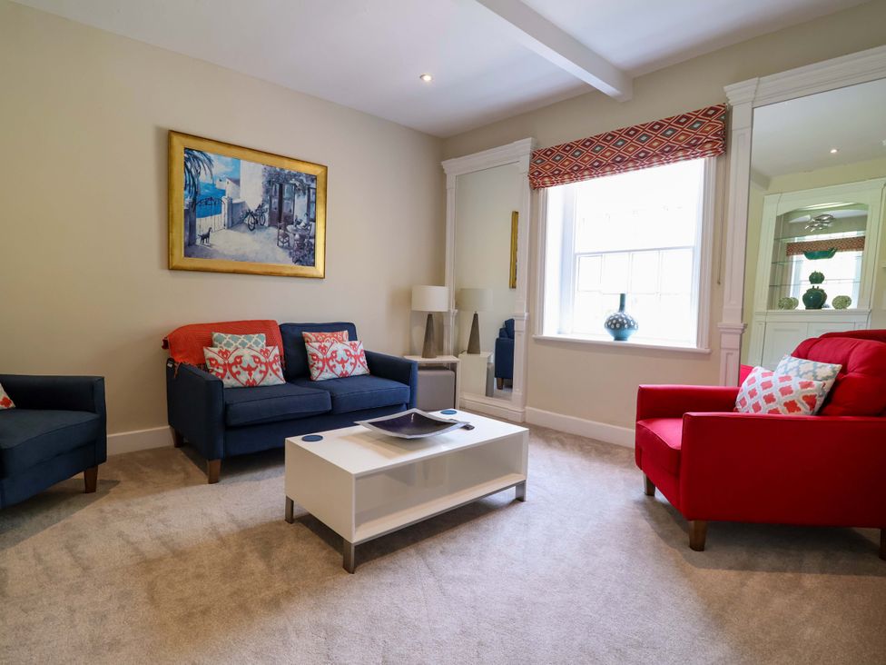 A living room with sofas, a coffee table and a painting at South Tower Cottage Capesthorne near Macclesfield