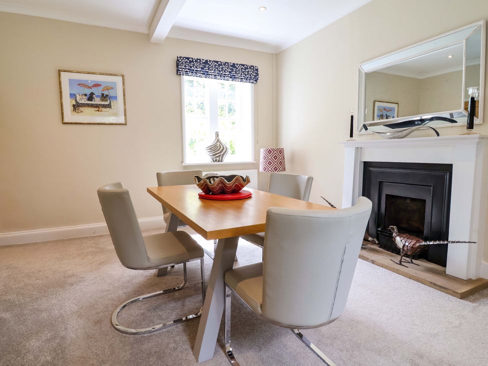 A dining room with a table, chairs, and a fireplace at South Tower Cottage in Capesthorne near Macclesfield