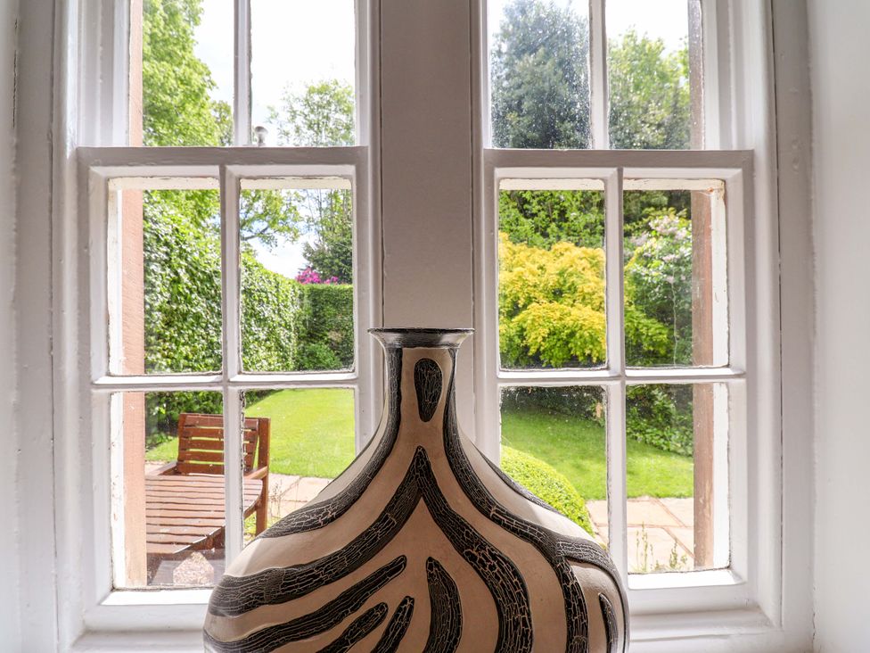 A vase on a window sill overlooking a garden at South Tower Cottage in Capesthorne near Macclesfield