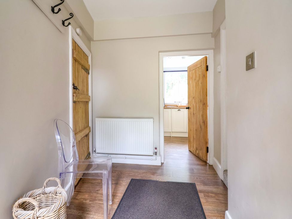 A hallway with a coatrack and a chair at South Tower Cottage in Capesthorne near Macclesfield