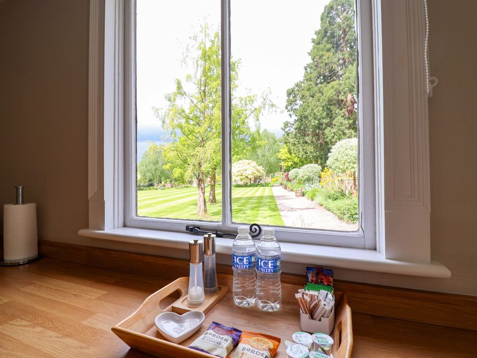 A window view showing a garden with a tray of water and condiments at South Tower Cottage Capesthorne near Macclesfield