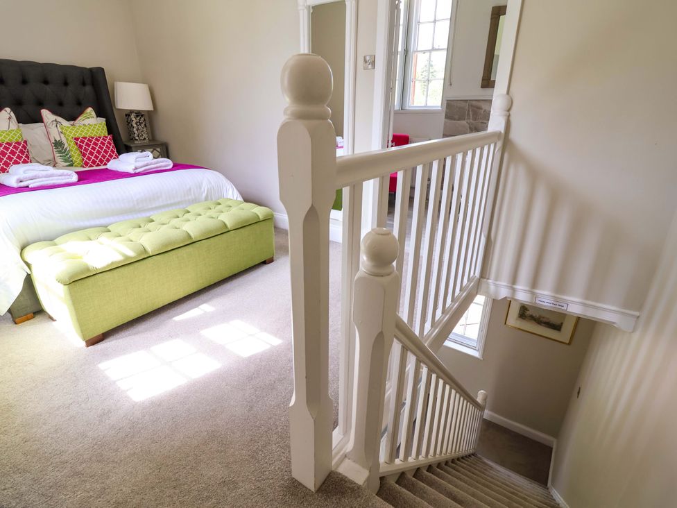 A bedroom with a bed and staircase at South Tower Cottage in Capesthorne near Macclesfield