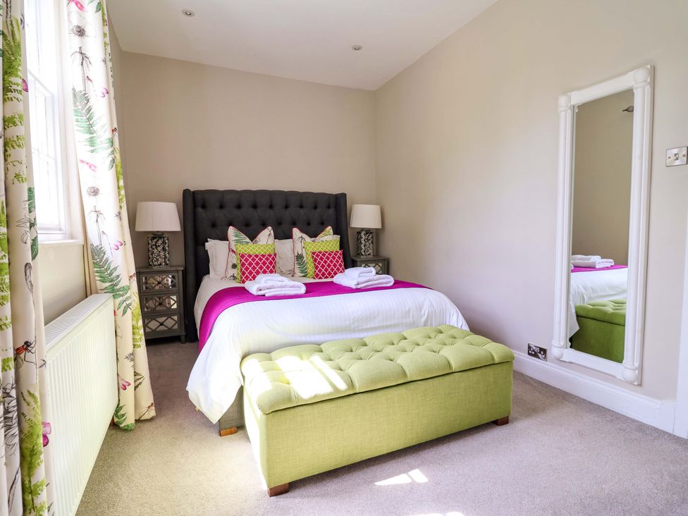 A bedroom with a bed and nightstands at South Tower Cottage in Capesthorne near Macclesfield