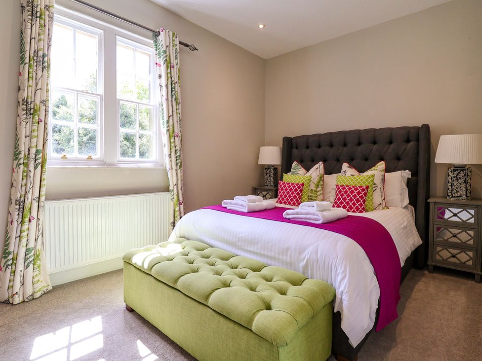 A bedroom with a bed and bedside tables at South Tower Cottage in Capesthorne near Macclesfield
