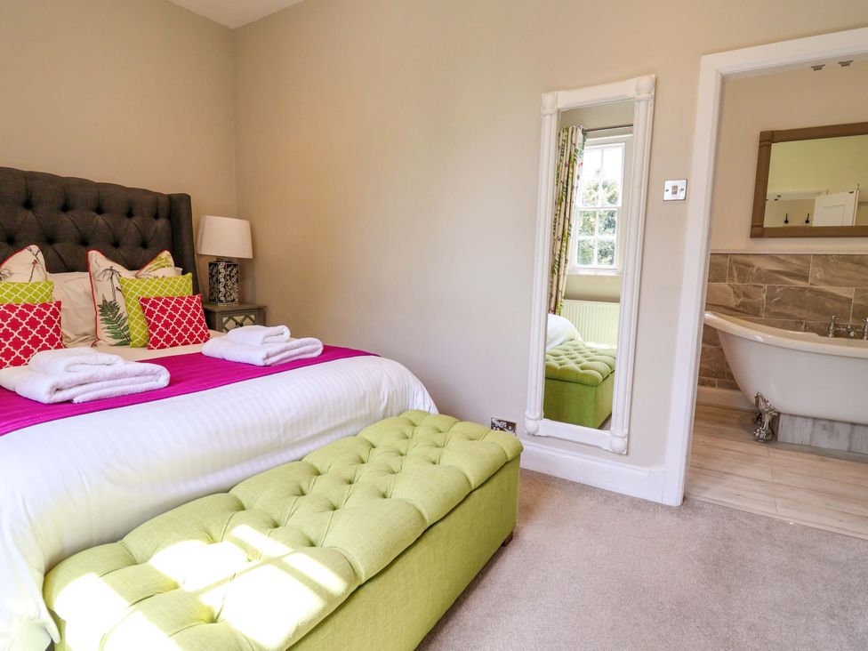 A bedroom with a bed and a bathtub at South Tower Cottage in Capesthorne near Macclesfield