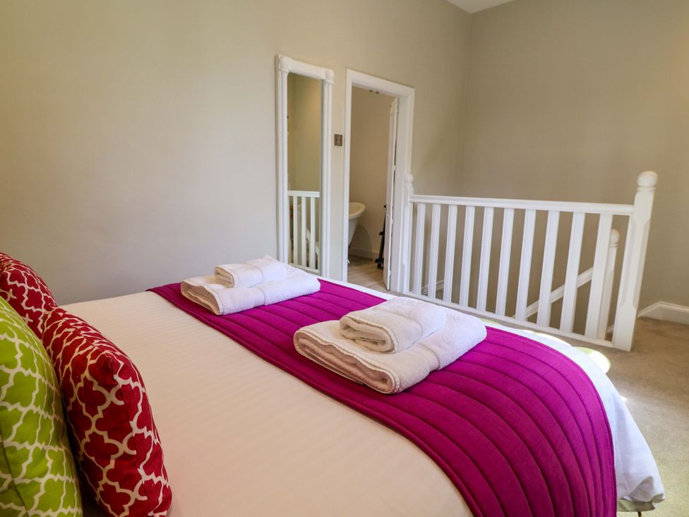 A bedroom with a bed and towels at South Tower Cottage Capesthorne near Macclesfield