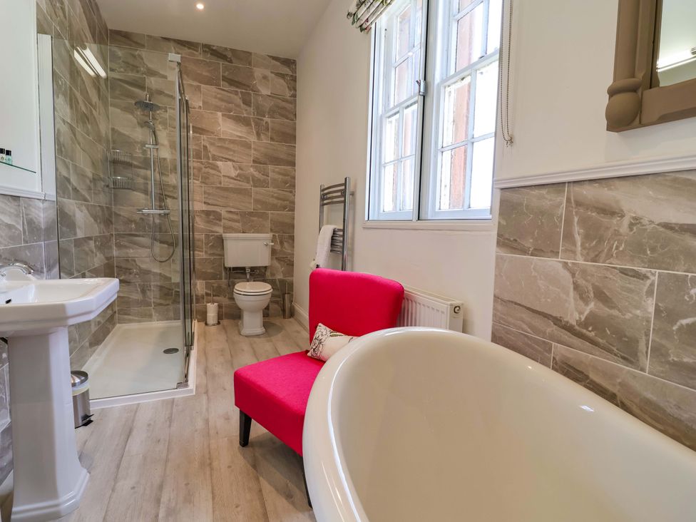 A bathroom with a shower, bathtub, and sink at South Tower Cottage Capesthorne near Macclesfield