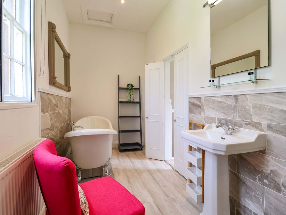 A bathroom with a bathtub and sink at South Tower Cottage Capesthorne near Macclesfield
