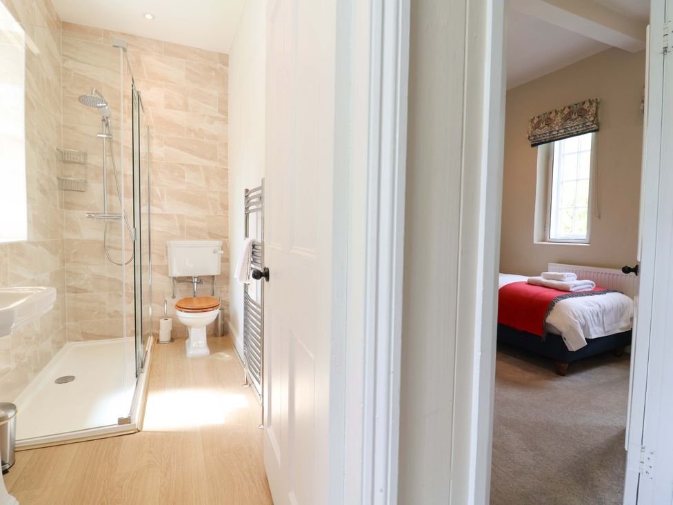 A bathroom with a shower and a bedroom with a bed at South Tower Cottage Capesthorne near Macclesfield