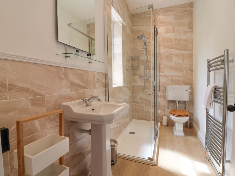 A bathroom with a shower, toilet, and sink at South Tower Cottage in Capesthorne near Macclesfield