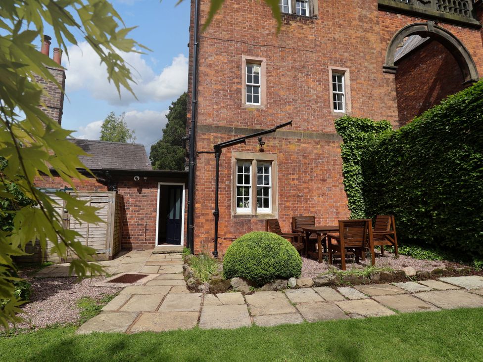 A garden with patio furniture and greenery at South Tower Cottage in Capesthorne near Macclesfield