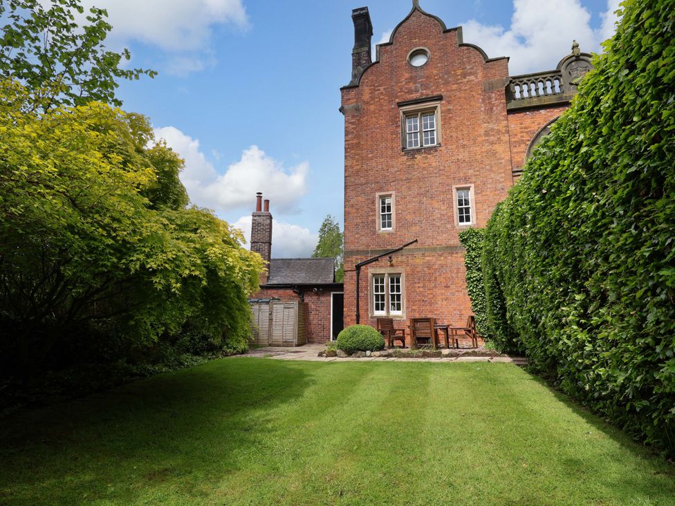 An outdoor area with a garden and patio furniture at South Tower Cottage in Capesthorne near Macclesfield