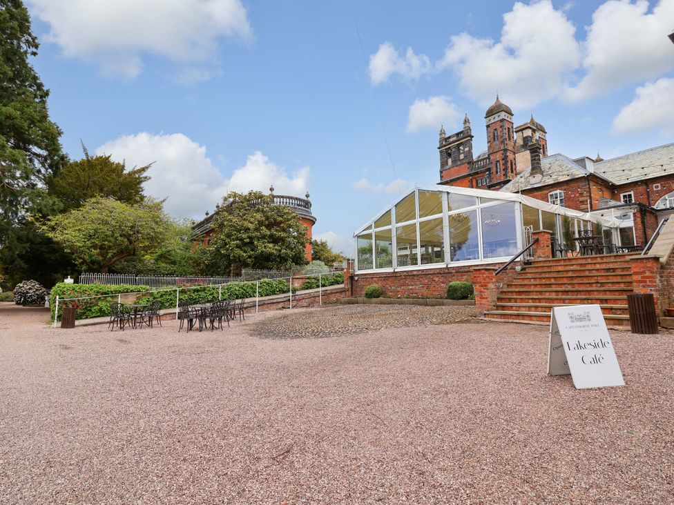 An outdoor café area with tables and chairs at South Tower Cottage in Capesthorne near Macclesfield