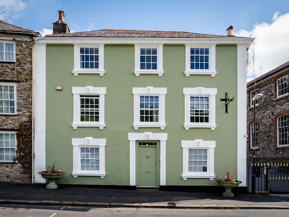 A green building with white trim and multiple windows at The Meeting House in Ashburton