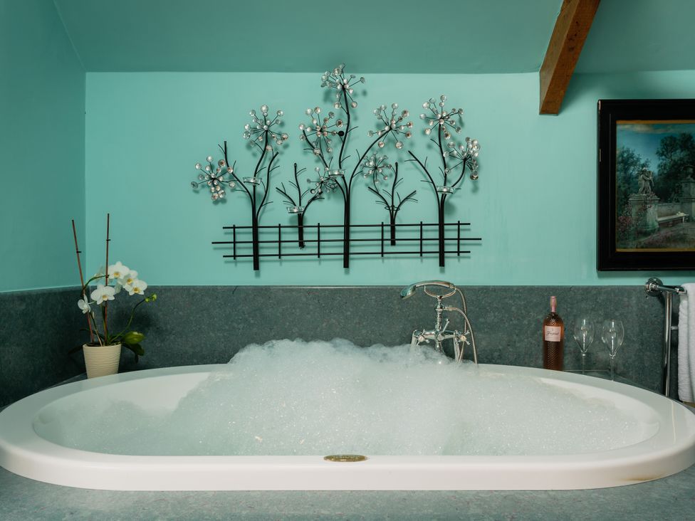 A bathtub with bubbles and decorative elements at The Meeting House in Ashburton