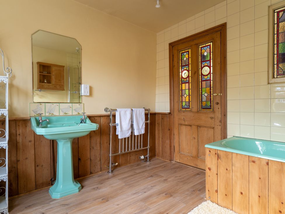 A bathroom with a green sink and bathtub at The Meeting House in Ashburton