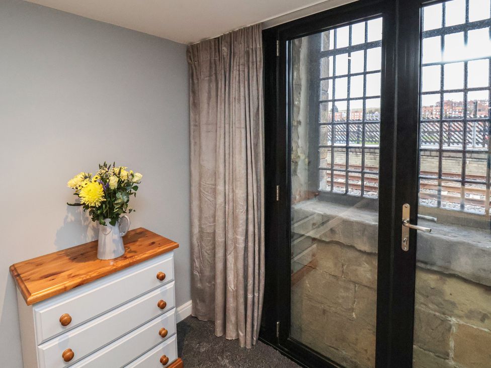 A bedroom with a dresser and flowers at Premier, Transit & Lady Hilda @ Engine Shed, Whitby
