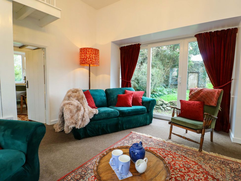 A living room with a green sofa and coffee table at Ael Y Bryn in Menai Bridge
