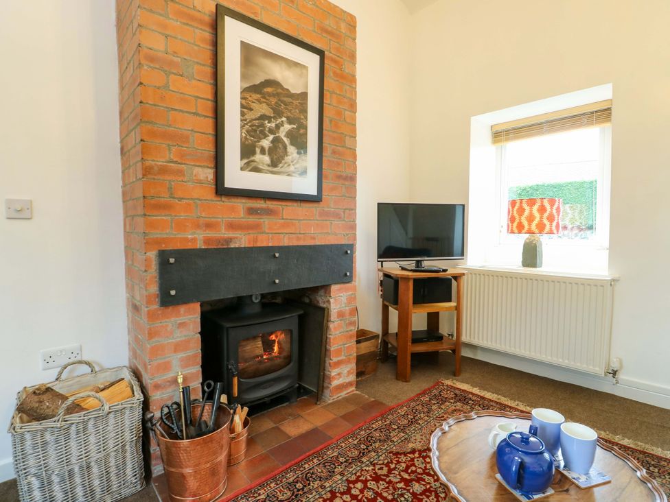 A living room with a fireplace and television at Ael Y Bryn in Menai Bridge