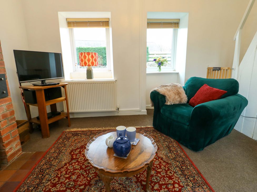 A living room with a television and sofa at Ael Y Bryn in Menai Bridge
