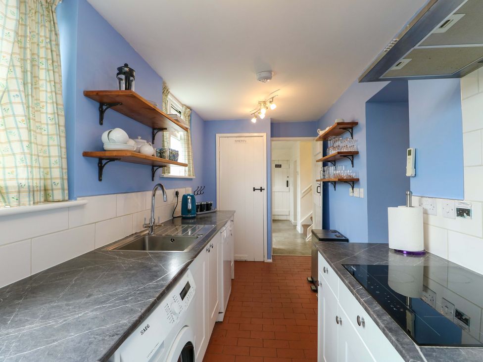 A kitchen with shelves and appliances at Ael Y Bryn in Menai Bridge