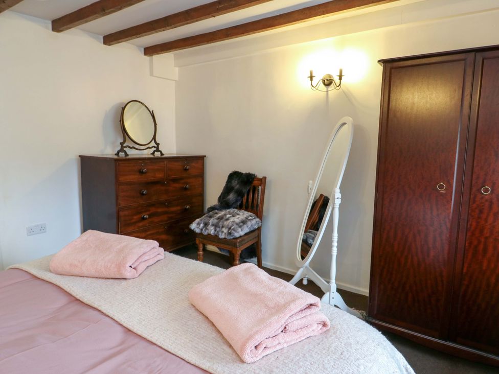 A bedroom with a bed, dresser, and mirror at Ael Y Bryn in Menai Bridge