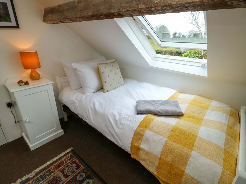 A bedroom with a bed and lamp at Ael Y Bryn in Menai Bridge