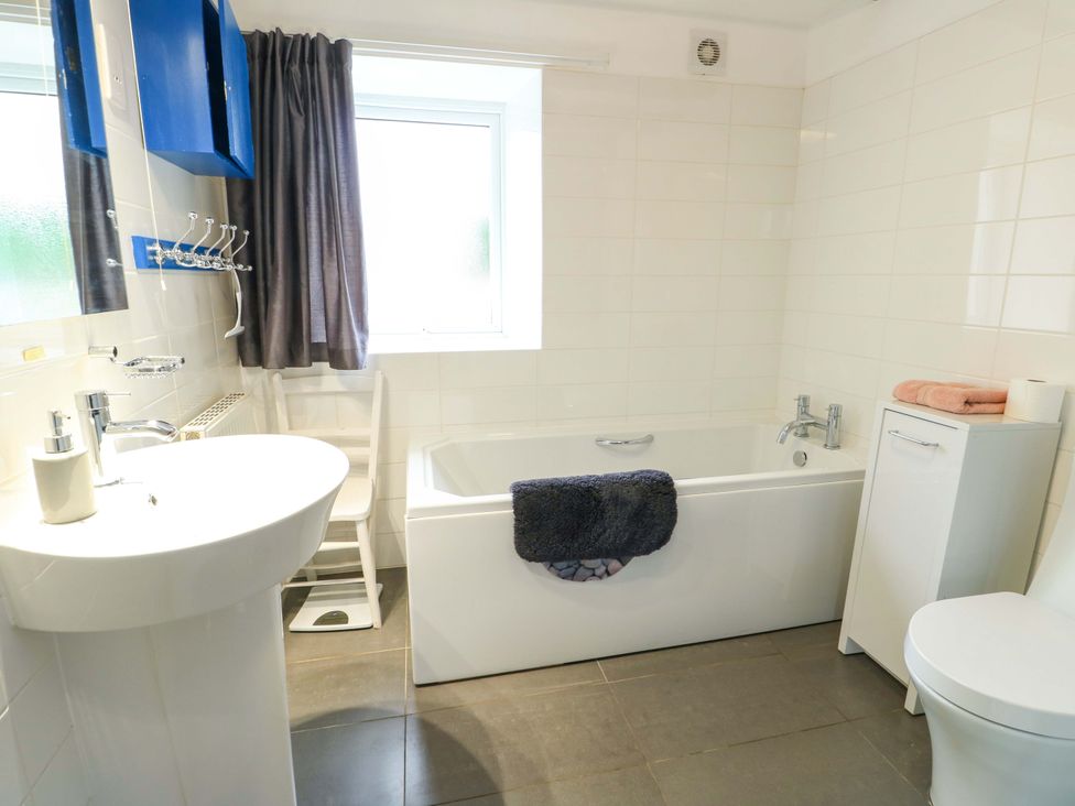 A bathroom with a bathtub, sink, and toilet at Ael Y Bryn in Menai Bridge