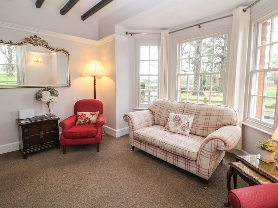 A living room with a sofa and chair in South Lodge - Longford Hall Farm Holiday Cottages Longford near Ashbourne