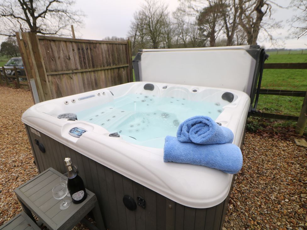 A hot tub with towels and champagne glasses at South Lodge - Longford Hall Farm Holiday Cottages Longford near Ashbourne