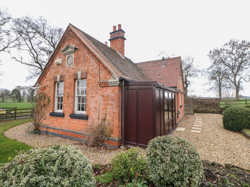 A brick house with windows and a chimney at South Lodge - Longford Hall Farm Holiday Cottages in Longford near Ashbourne