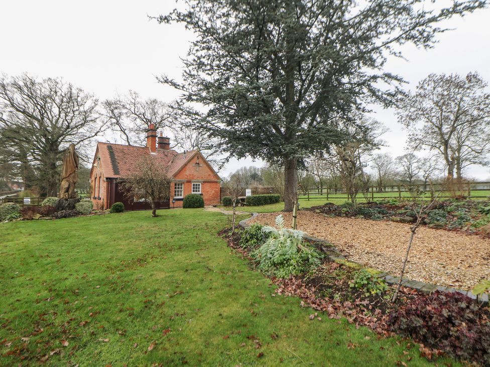 An outdoor area with a brick house and trees located at South Lodge - Longford Hall Farm Holiday Cottages Longford near Ashbourne