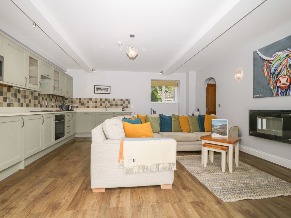 A living room with a kitchen area and sofa at High Spy in Keswick